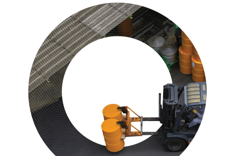 An aerial shot of a forklift moving yellow drums in an industrial storage yard filled with various chemical containers, representing inventory management in the chemical sector.