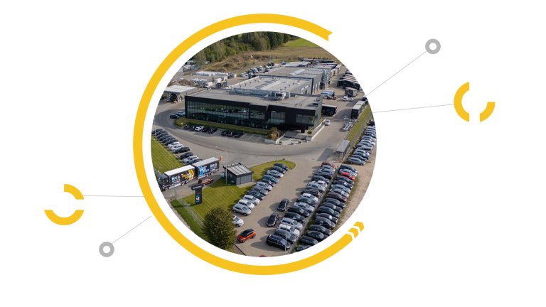 Aerial view of a large office building with numerous parked cars surrounding it Aerial view of a large office building with numerous parked cars surrounding it
