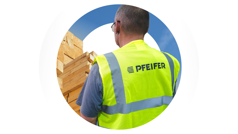ückansicht eines Logistikmitarbeiters in einer gelben Warnweste mit Pfeifer-Logo, der auf gestapeltes Schnittholz blickt, eingerahmt in einem kreisförmigen Design.