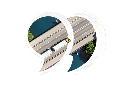 An aerial view of a commercial truck driving across a highway bridge over water, creatively framed within large quotation marks to symbolize customer voices and success stories in the freight exchange and spot market.