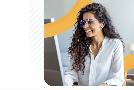 A smiling woman with long curly hair and glasses works at a computer, wearing wireless earbuds, framed by professional orange graphic curves.