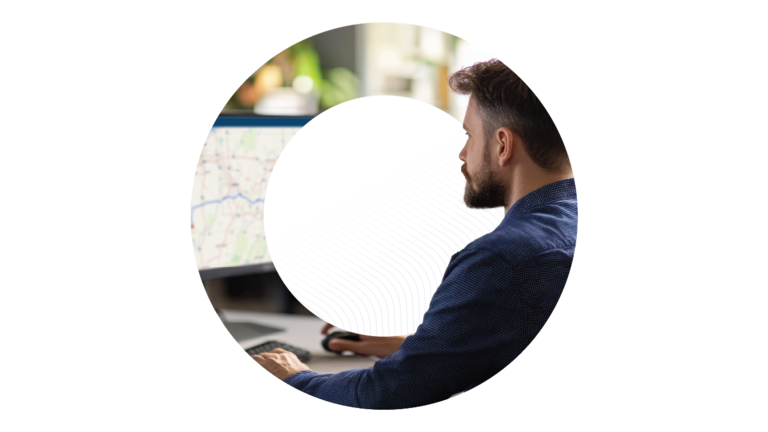 Ein Logistikexperte betrachtet eine digitale Karte auf einem Computerbildschirm, umrahmt von einer kreisförmigen Grafik.
