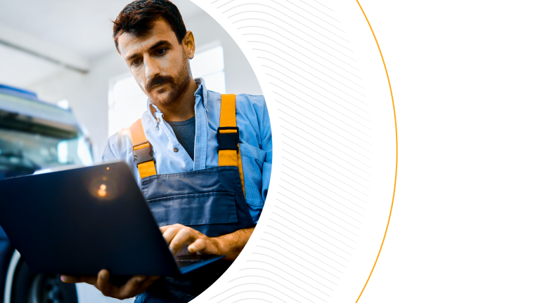 A warehouse worker in blue overalls using a laptop in front of a truck, framed by a curved graphic, representing digital tools for logistics and transportation management.