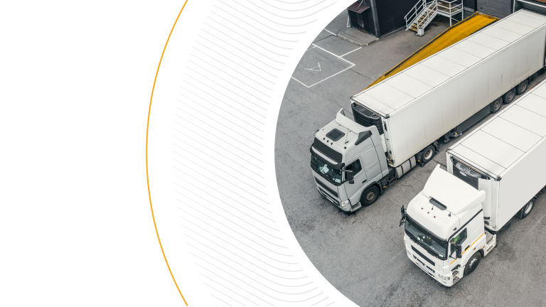An aerial view of white semi-trucks parked next to a loading dock, cropped in a stylized arc shape, illustrating fleet operations and logistics infrastructure.
