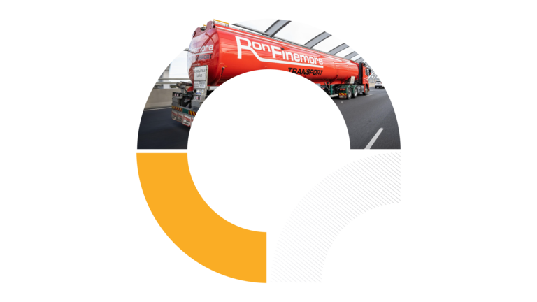 A circular graphic cropped into a semicircle, showing a red semi-trailer truck parked on an asphalt road under a bright sky.