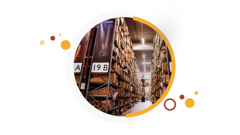 Warehouse aisle with guitar cases on labeled shelving, part of Thomann's Peripass solution