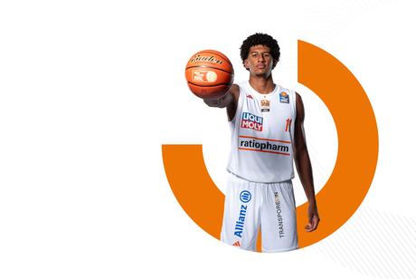 ratiopharm ulm basketball player holding a basketball in front of Transporeon brand graphics.