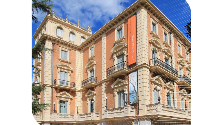 Exterior of the historic Museo Lázaro Galdiano building in Madrid with orange banners, featured for the Spain leadership event.