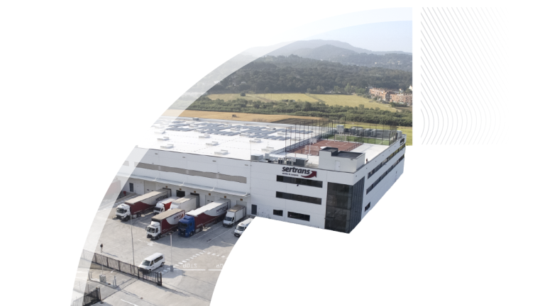 An aerial view of a large white Sertrans warehouse and distribution center with trucks parked at the loading docks, cropped in a stylized curved arc shape.